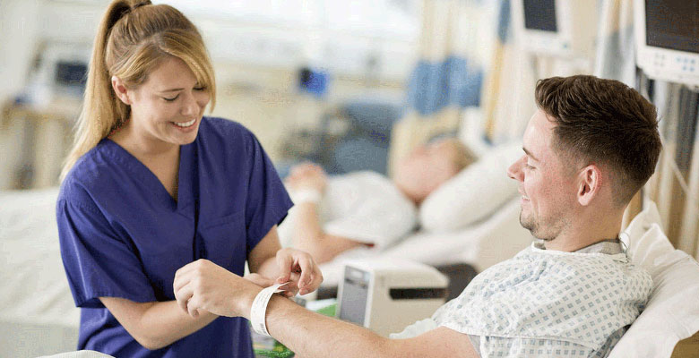 Medicinska sestra stavlja narukvicu na zglob pacijenta